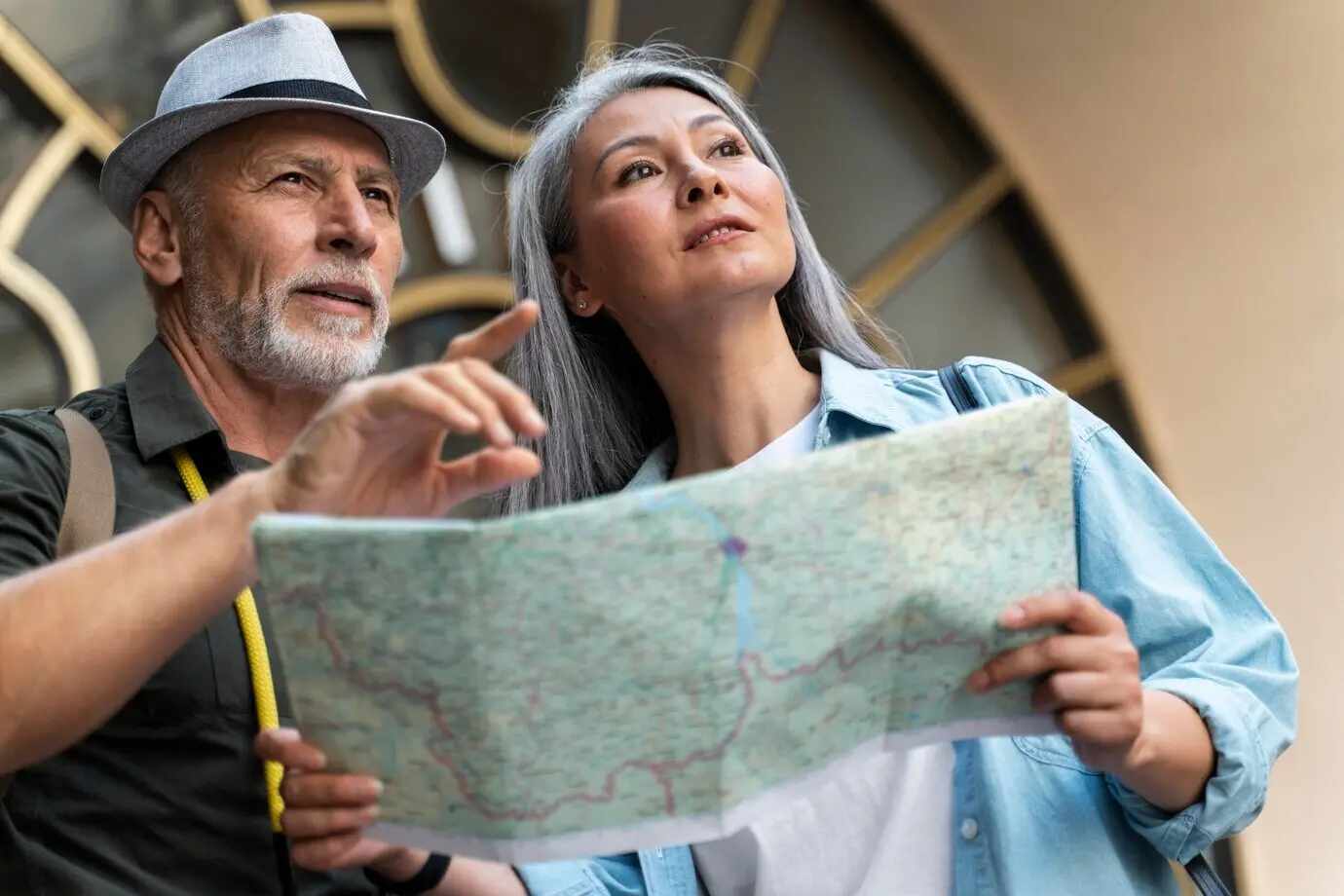 Halbnahe Aufnahme eines Seniorenpaares mit Weltkarte.